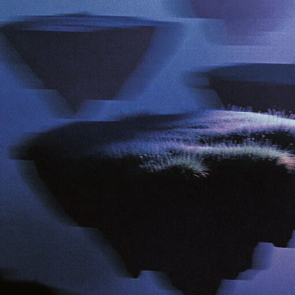 several floating landmasses with jagged rocky undersides and tufted grassy plateaus suspended in a thick nebulous sky, massive foreground island offset by distant receding landmasses, captured in a lo-fi digital glitch aesthetic with dense chromatic grain and heavy horizontal motion blur, dark indigo and violet color grade, high-contrast silhouette treatment, smeary highlights, pixelated analog video artifacts, dithered texture, eerie dreamcore atmosphere, under-exposed lighting