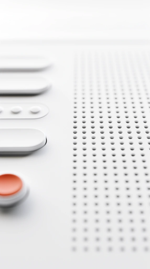 An extreme close-up of a minimalist white electronic interface featuring a perforated speaker grill and smooth pill-shaped buttons. The right half of the composition is dominated by a precise geometric grid of small circular holes receding into a soft blur. On the left, elevated oblong keys and tiny circular tactile bumps sit alongside a single circular button with a muted orange-red top, providing the only pop of color against the matte white surface. The macro perspective utilizes an extremely shallow depth of field, heavily blurring the foreground and background while maintaining sharp focus on the midground elements. Bright, diffused high-key studio lighting creates subtle drop shadows and gentle highlights across the pristine monochromatic curves of the control panel.