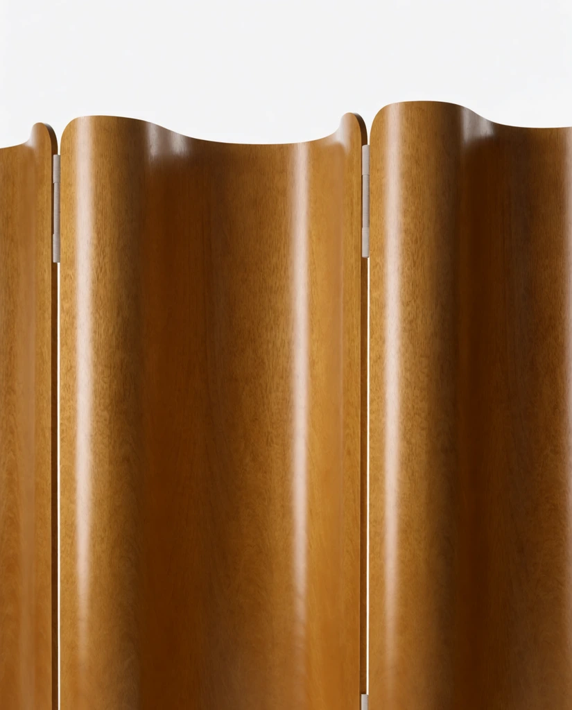 A close-up of an undulating wooden room divider against a stark white studio background. The sculptural screen is composed of vertical, wavy panels showcasing a rich golden-brown wood grain with a glossy finish. Thin, light grey fabric hinges connect the curved sections, integrating seamlessly into the corrugated profile. The top edge forms a continuous, gentle wave matching the folds. Soft, diffused lighting casts smooth vertical highlights along the convex curves, emphasizing the minimalist design.