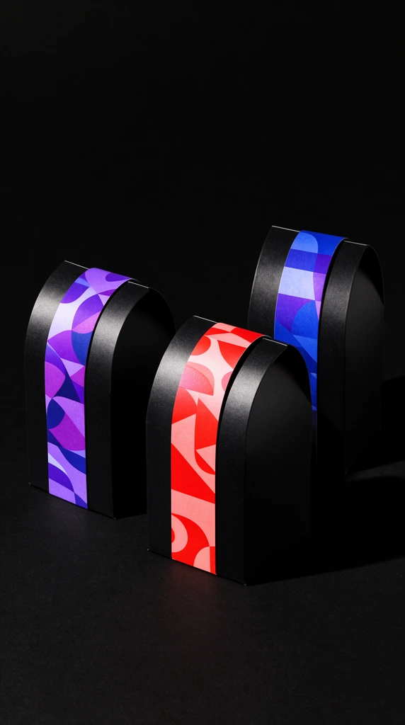 three black arched packaging boxes on a pitch-black surface, vibrant vertical bands with abstract red, purple, and blue geometric patterns, hard directional studio lighting, sharp shadows, minimalist high-contrast product photography