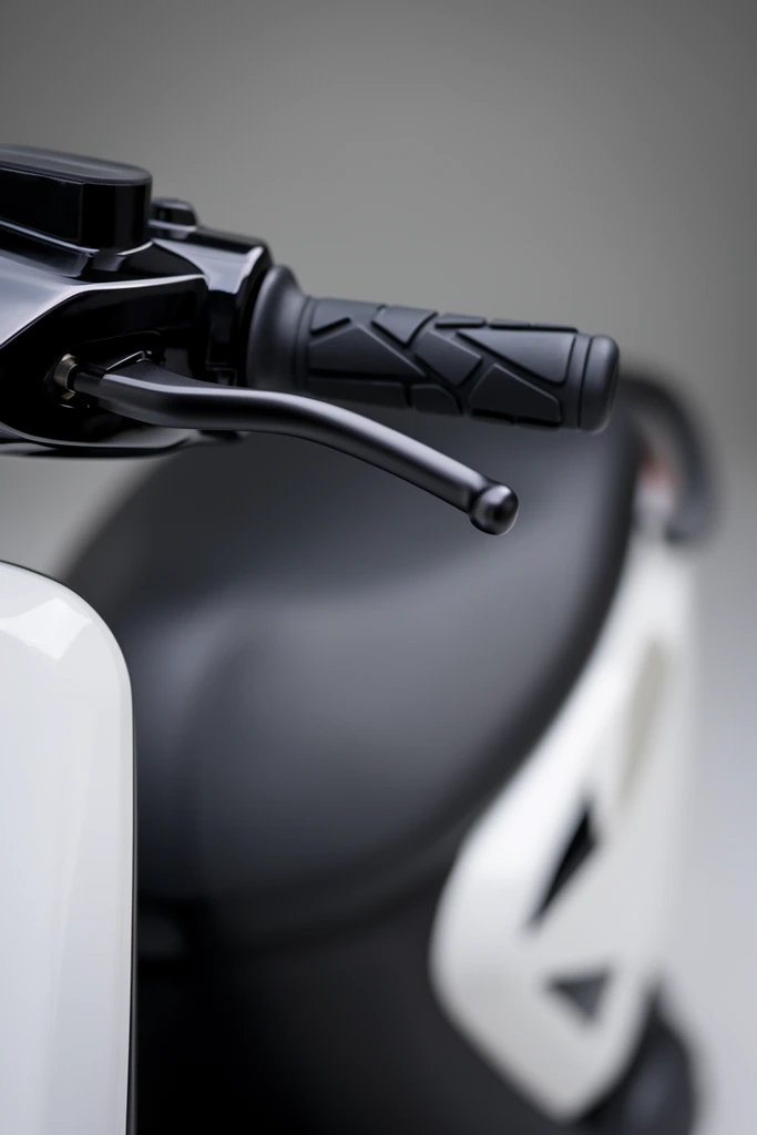 A macro product shot focuses sharply on the black handlebar and brake lever of a modern minimalist scooter against a soft gray gradient background. The black rubber handgrip, textured with geometric raised ridges, extends horizontally from a glossy black control housing. A curved, matte black metal brake lever arcs downward beneath the grip. In the heavily blurred background, the curved contours of a matte black seat and a glossy white side panel with dark triangular accents recede into soft bokeh. The left foreground features an out-of-focus glossy white front fairing. The composition uses an extremely shallow depth of field to isolate the mechanical hardware. Soft, diffused studio lighting highlights the interplay of matte and glossy surfaces, emphasizing the sleek monochromatic industrial aesthetic.