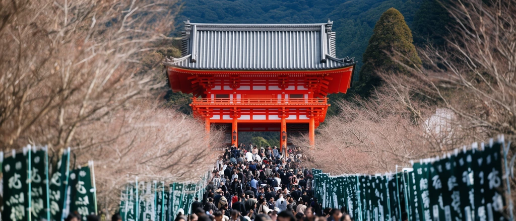 massive vermilion traditional shrine gate, dense crowd walking up a wide path, dark green vertical banners, bare trees framing the scene, forested mountain background, telephoto compression