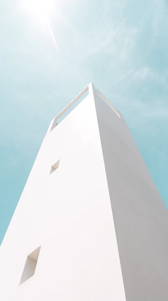 stark white minimalist geometric tower against a pale blue sky, extreme low-angle perspective, brilliantly lit flat facade with two small square window cutouts, adjacent angled face in soft gray shadow, small open architectural framework at the apex, pastel cyan sky with faint wispy clouds, ethereal high-key daylight with bright sun glare, clean structural lines, minimalist architectural photography