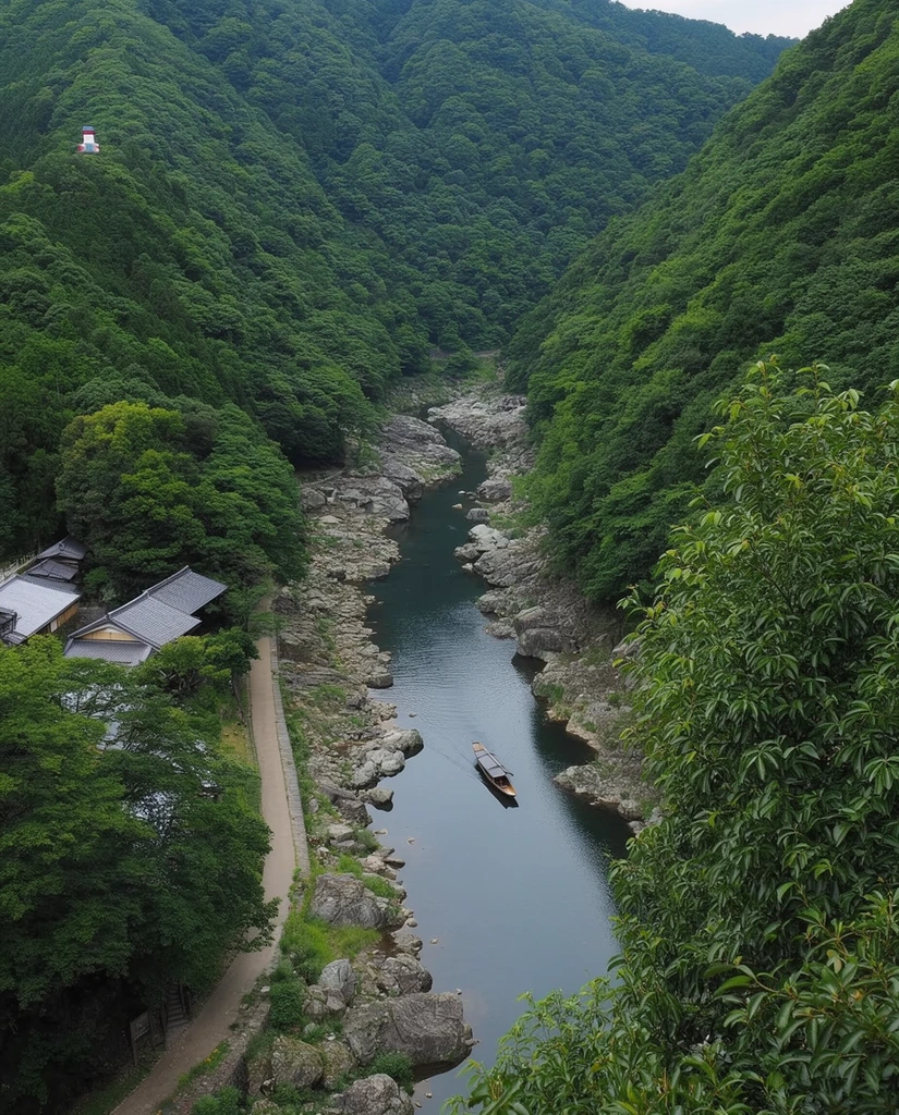 An elevated view of a dark river winding through a steep, V-shaped mountain gorge densely covered in lush green forest. A traditional long wooden boat leaves a faint wake on the calm water, navigating past large gray boulders lining the rocky riverbed. A narrow paved path runs along the left bank, adjacent to traditional buildings with sloping dark gray roofs nestled among the trees. A tiny white and red structure sits perched high on the distant left ridge. The high-angle perspective guides the eye along the serpentine river toward the distant valley. Soft, diffused natural daylight illuminates the tranquil scene, with leafy branches framing the right foreground for added depth.
