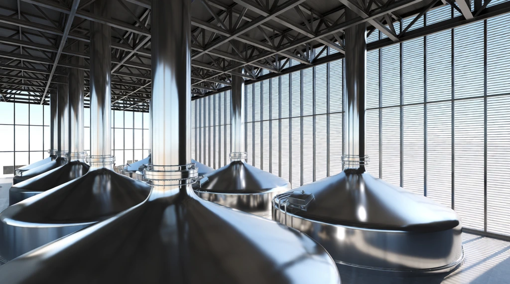 Modern industrial facility interior, elevated perspective, large polished stainless steel conical vats, highly reflective surfaces, vertical pipes, dark exposed steel truss ceiling, massive slatted glass windows, bright daylight, 3D architectural rendering