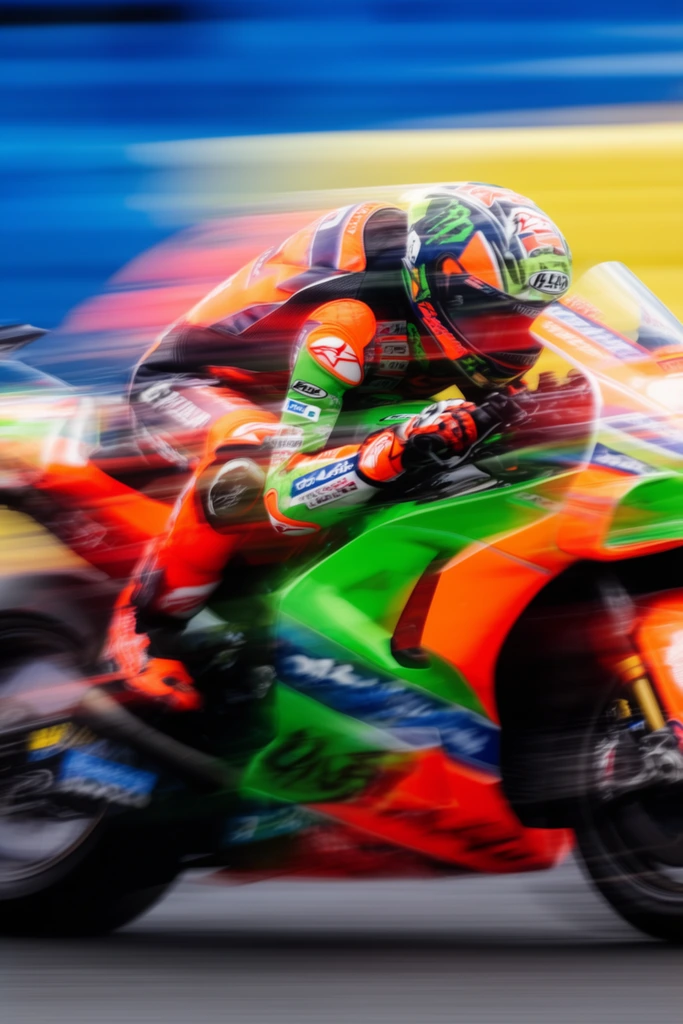 high-speed motorcycle racer, extreme horizontal motion blur, neon orange and green fairings, tucked rider, streaked blue and yellow background, dynamic panning photography