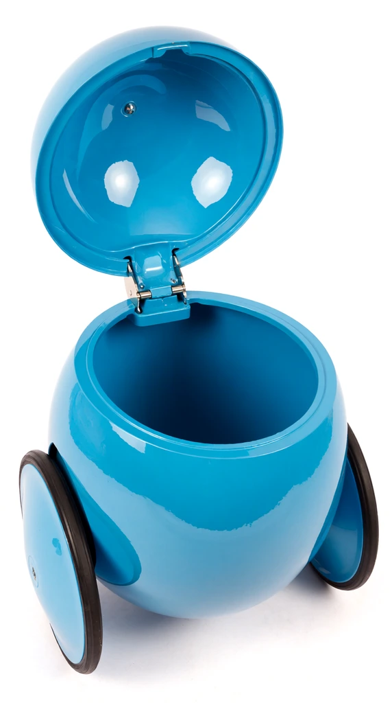 A glossy cyan-blue spherical storage pod with an open hinged lid sits against a seamless white studio background. Two slim wheels with black rubber tires flank the smooth curved body. The open lid reveals a deep empty interior cavity molded in the same bright blue material, connected by silver metal hinges. High-angle product photography features even lighting creating sharp specular highlights on the highly reflective retro-futuristic surface.