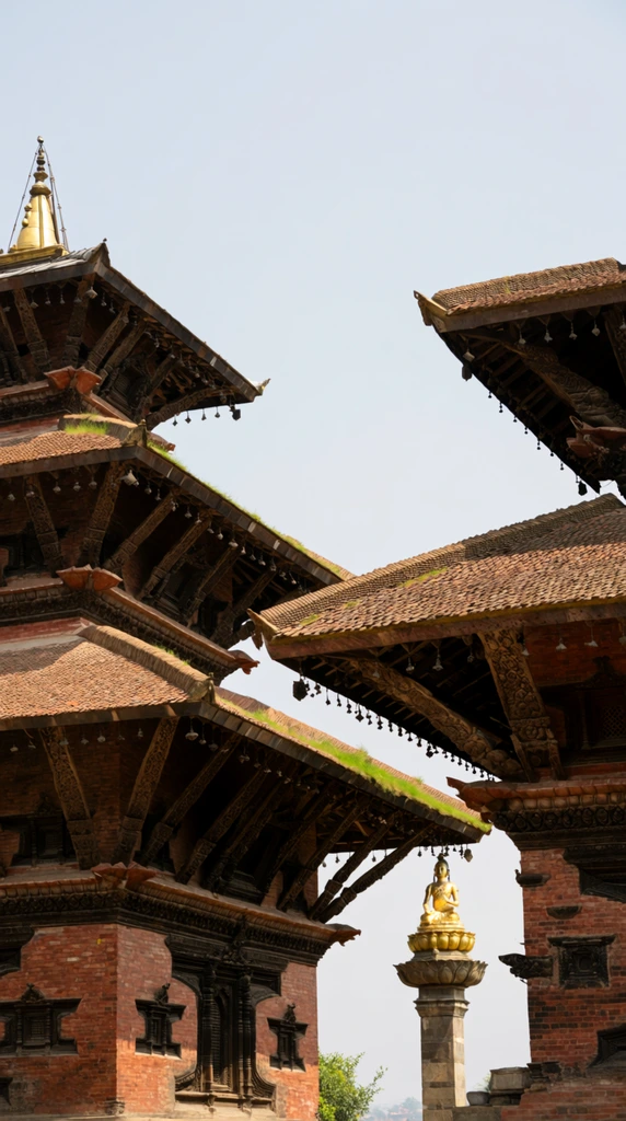 Two multi-tiered pagoda temples tower against a pale, clear sky. The prominent left structure features weathered reddish-brown brick walls punctuated by dark, intricately carved wooden windows and angled struts. These supports hold three sloping, terracotta-tiled roofs accented with patches of green grass along their edges and topped with a slender golden finial. On the right, a matching temple displays deeply shadowed, ornate wooden eaves overhanging a textured roof. Framed in the background between the buildings, a stone pillar elevates a gleaming golden statue of a seated figure on a decorative lotus pedestal. The low-angle architectural photography captures the grand scale, rich material contrast of brick and wood, and detailed historic craftsmanship under soft, diffused daylight.