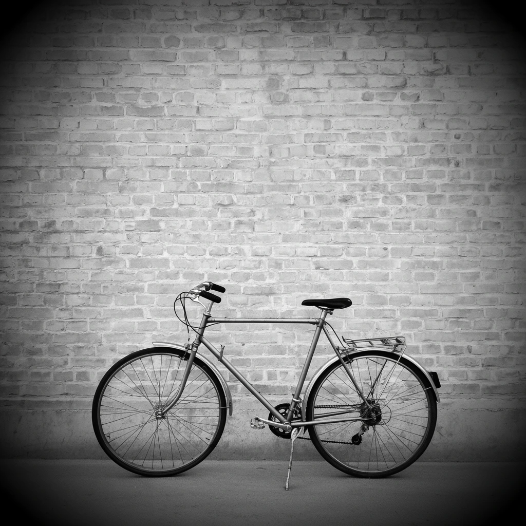 A minimalist black and white photograph featuring a classic commuter bicycle resting on its kickstand against a weathered brick wall. The bicycle, positioned in the lower third of the frame and facing left, features a straight top tube, curved handlebars, front and rear fenders, a rear cargo rack, and an exposed rear derailleur gear system. The ground is a smooth, continuous slab of pavement. A pronounced dark vignette surrounds the scene, intensely shadowing the corners and bottom edge, drawing focus to the lighter central area of the brickwork and the intricate mechanical details of the bicycle spokes and frame. The composition is strictly head-on, creating a stark, high-contrast urban scene.