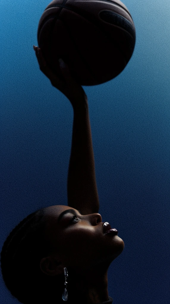 A low-angle cinematic portrait of a person extending a long arm upward to balance a dark basketball. Framed at the bottom edge in heavy shadow, the subject's profile catches a sharp highlight on glossy lips and a dangling silver earring. The deep blue gradient background features heavy film grain.