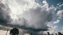 A dramatic time-lapse showing storm clouds rolling in over an open landscape or cityscape, captured over 2-4 hours compressed into 10-15 seconds. Highly sped-up footage. Set up a locked-off camera on a sturdy tripod in a location with an interesting foreground element (lone tree, building, or monument) and expansive sky. Shoot one frame every 3-5 seconds depending on cloud speed, maintaining consistent exposure despite changing light conditions. Frame with roughly two-thirds sky to emphasize the meteorological drama. Capture the progression from clear or partly cloudy to ominous storm clouds, including the dramatic shift in lighting as the sun is obscured.